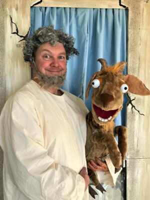 Craig is in character as Pythagoras holding a stuffed toy goat.