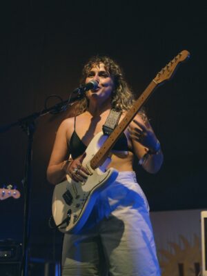 Peri Rae performing with her guitar.