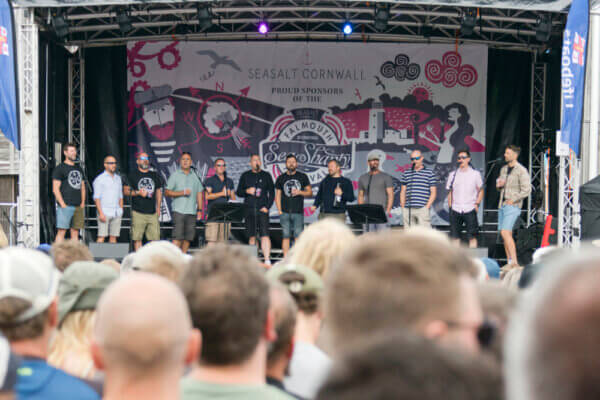 Long distance shot of the Oggymen performing on stage at Falmouth Sea Shanty Festival.